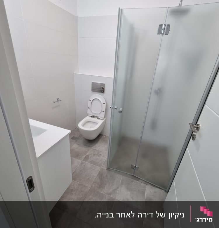 חדר אמבטיה עם מקלחון ודלת זכוכית